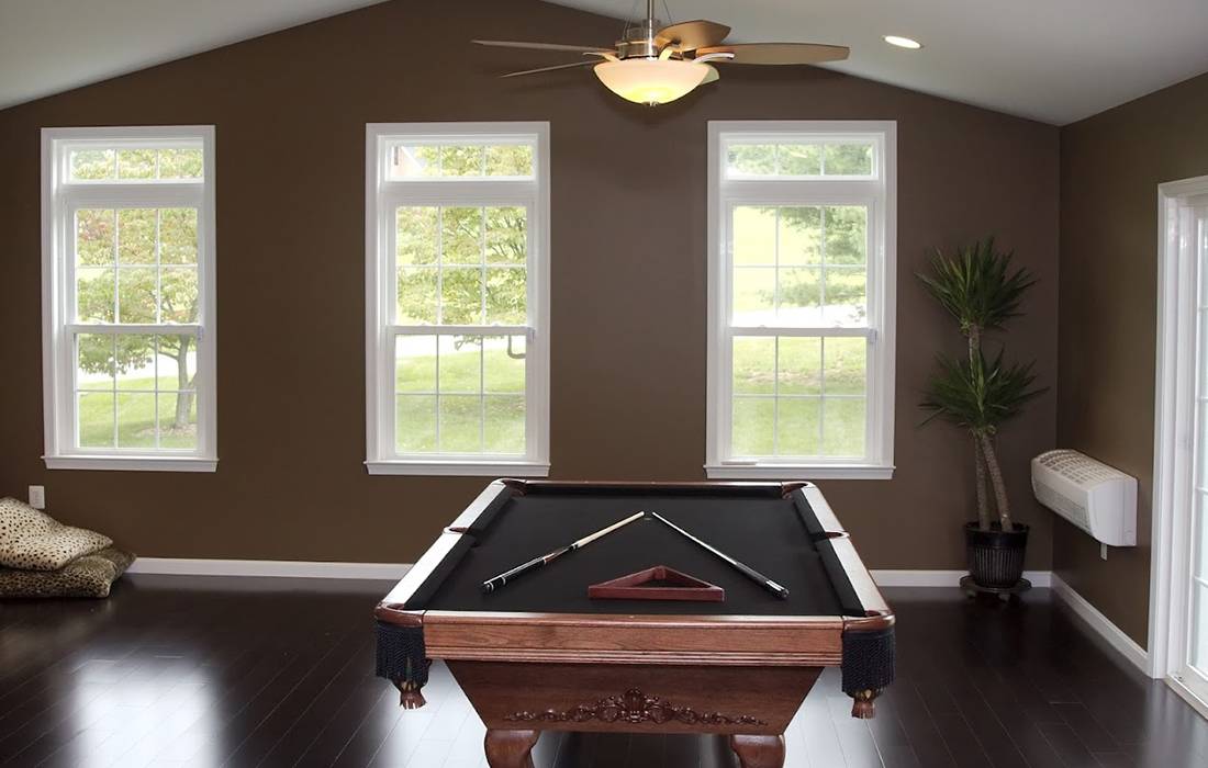 new room with a pool table, sloped ceilings, a ceiling fan, & hardwood floors