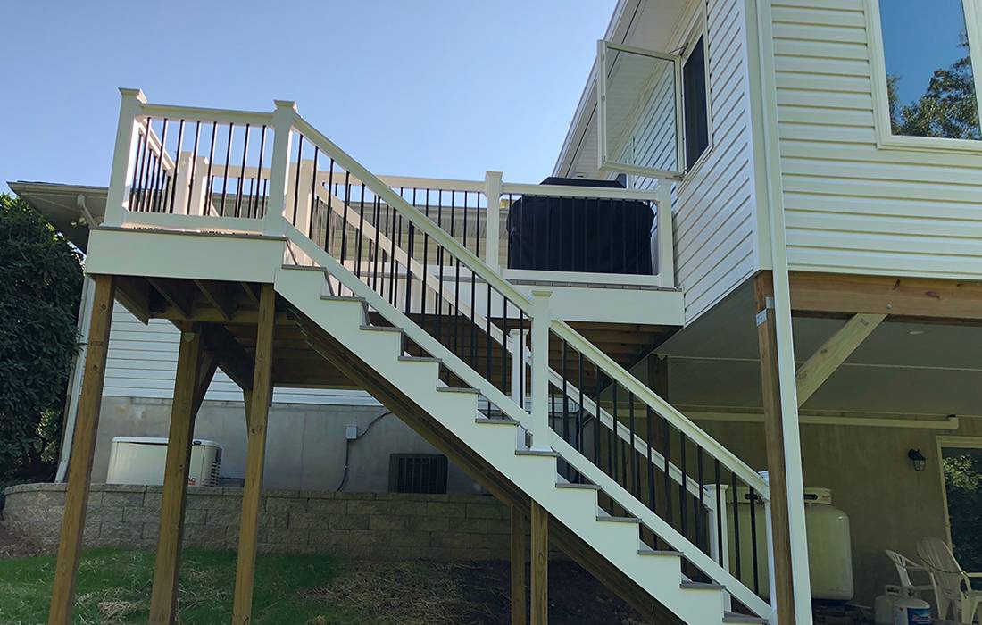 a staircase & railing leading to a back patio of a house with matching siding