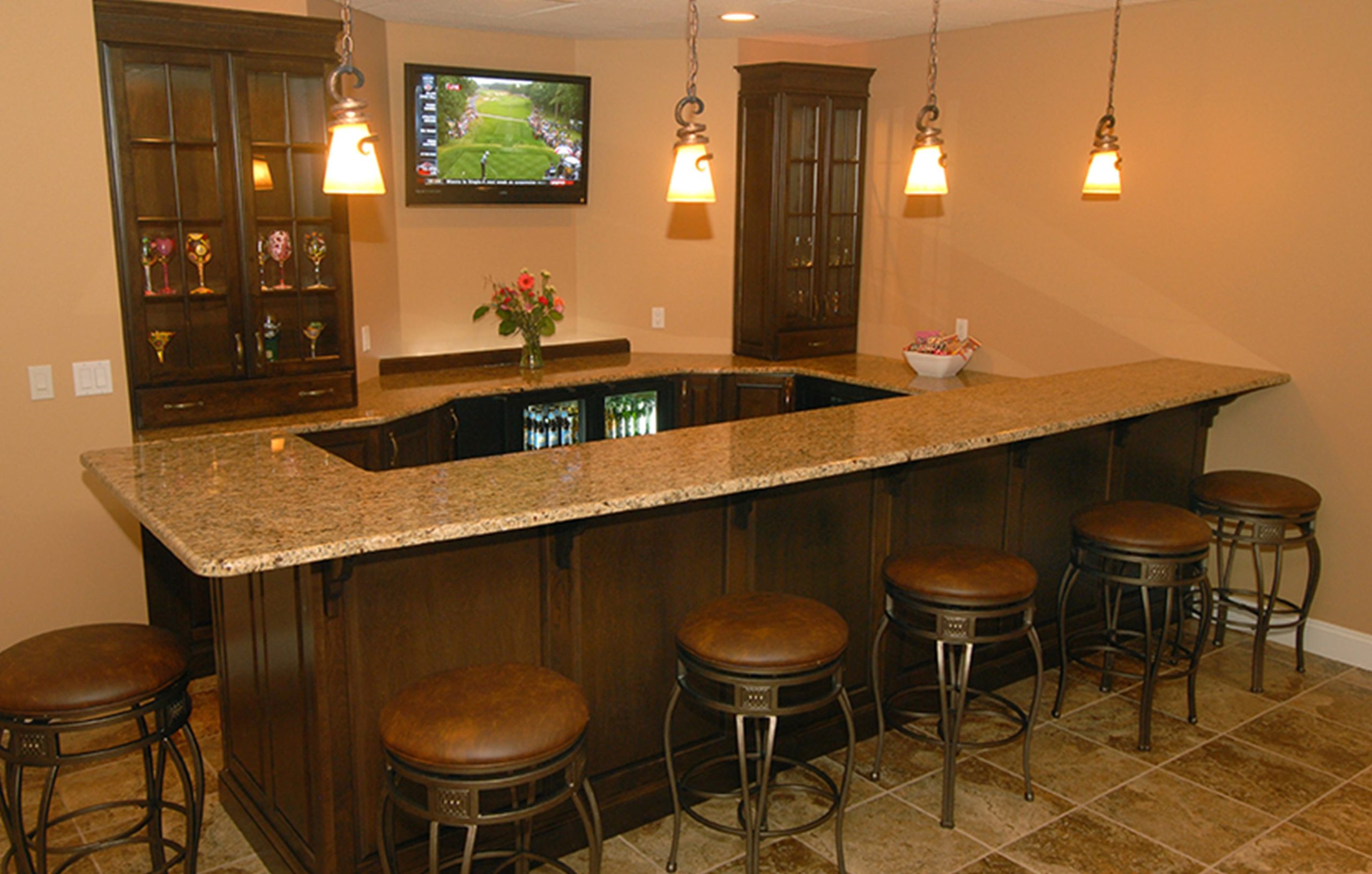 Granite top bar installed inside a residential home including room for barstools and refrigeration