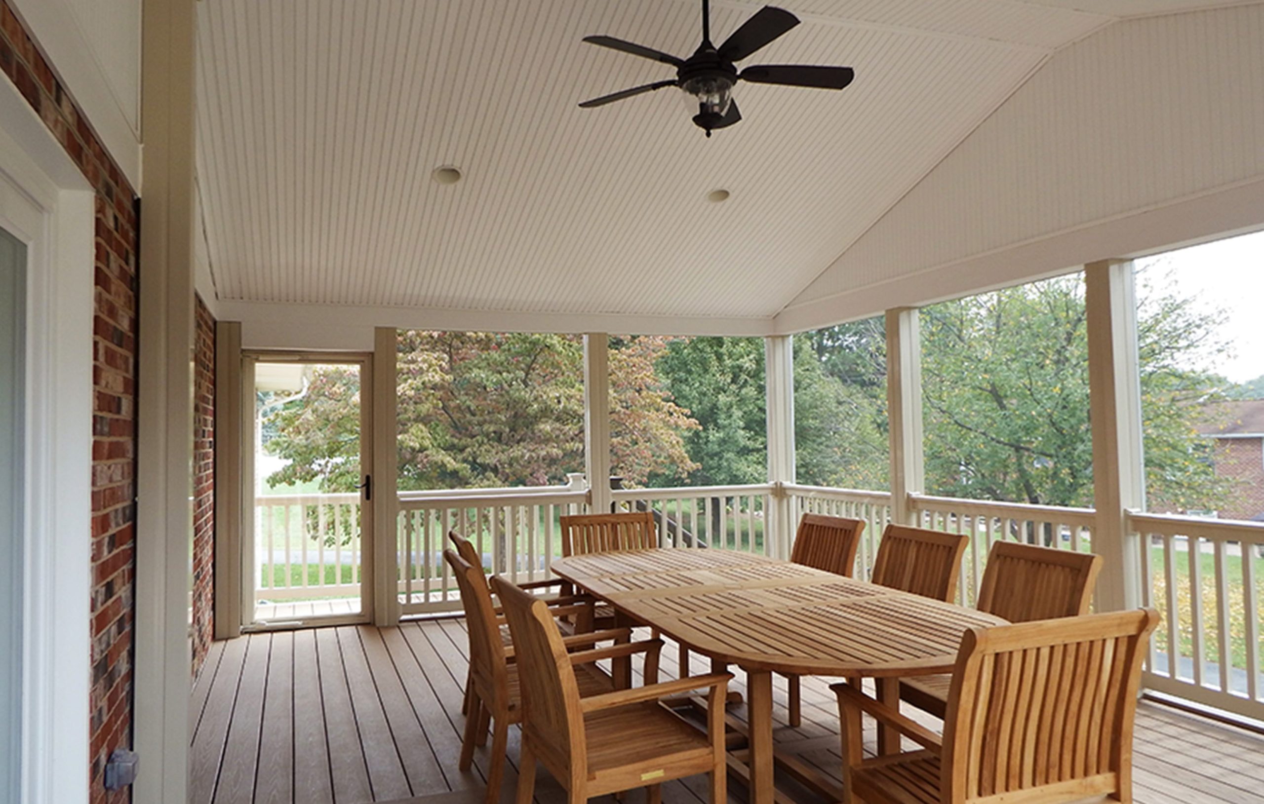 Wood deck screened in sun room added onto residential home