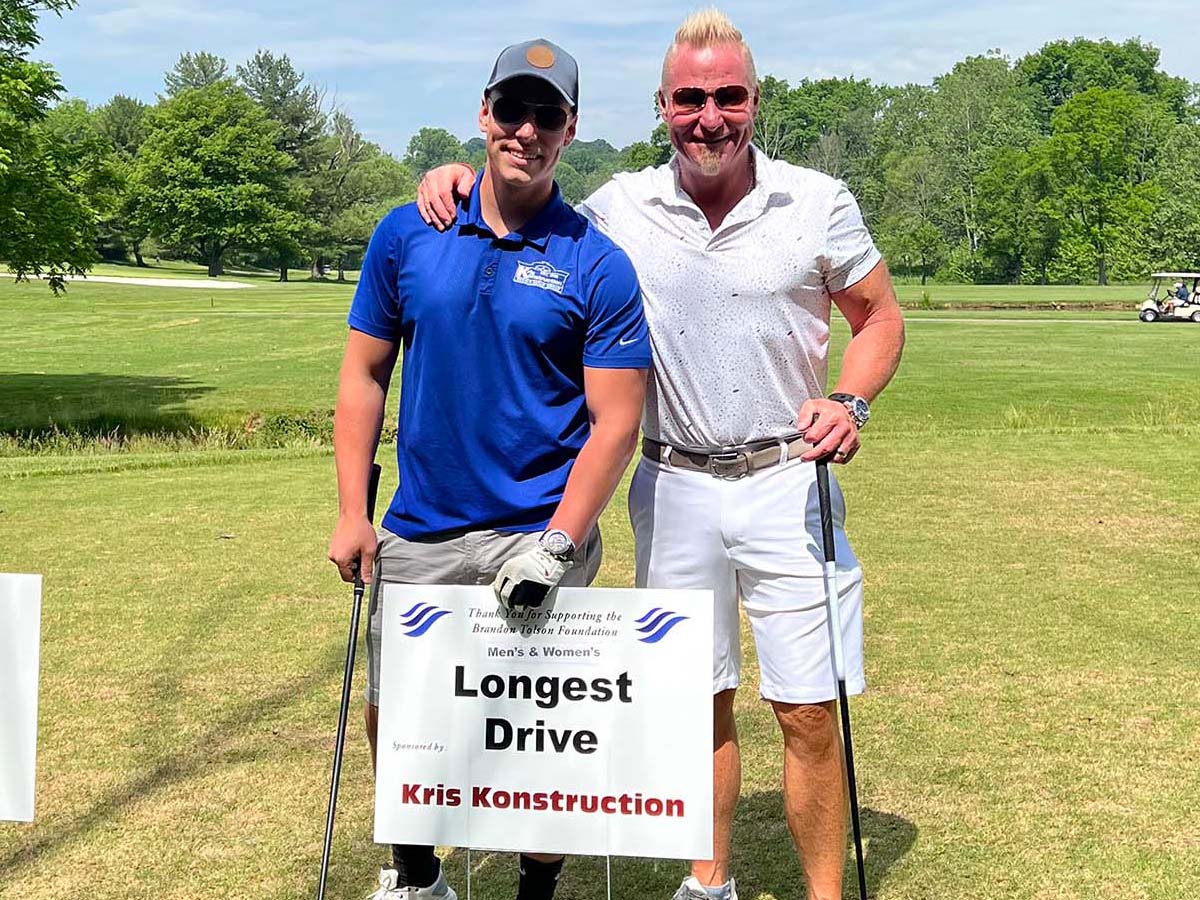 two smiling Kris Konstruction employees at a charity golf event