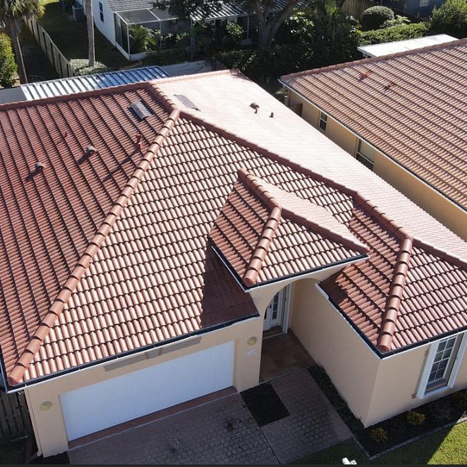 Overhead view of a red tile roof on a tan single story house