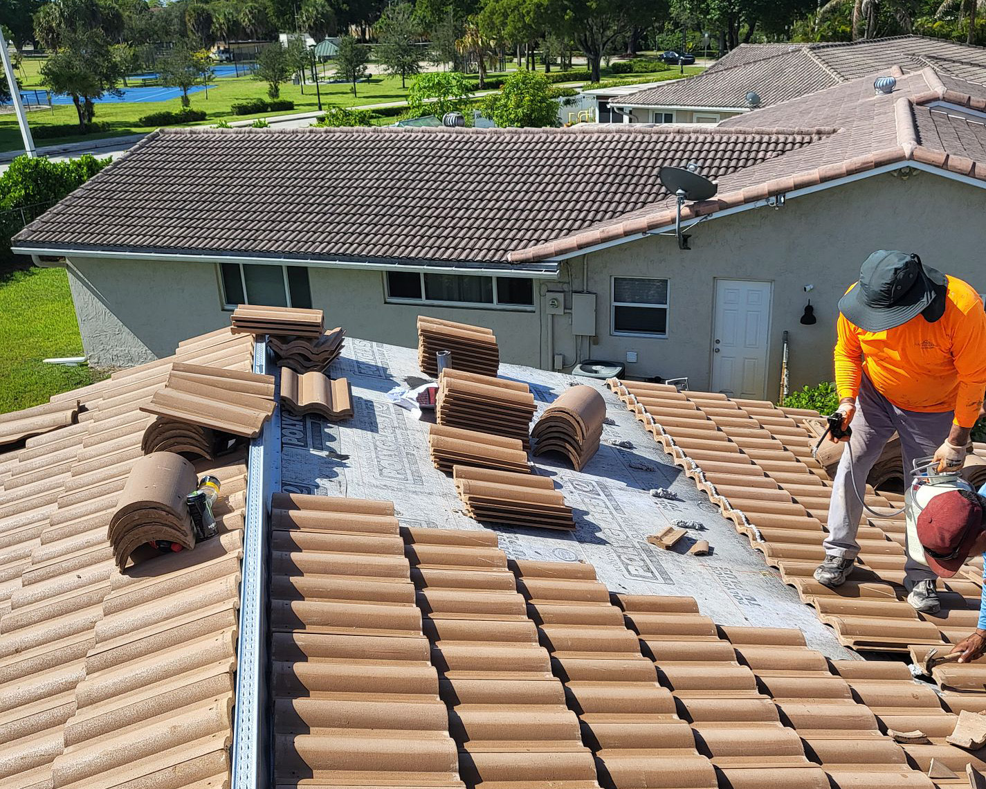 Kris Konstruction replacing a orange residential roof with two employees
